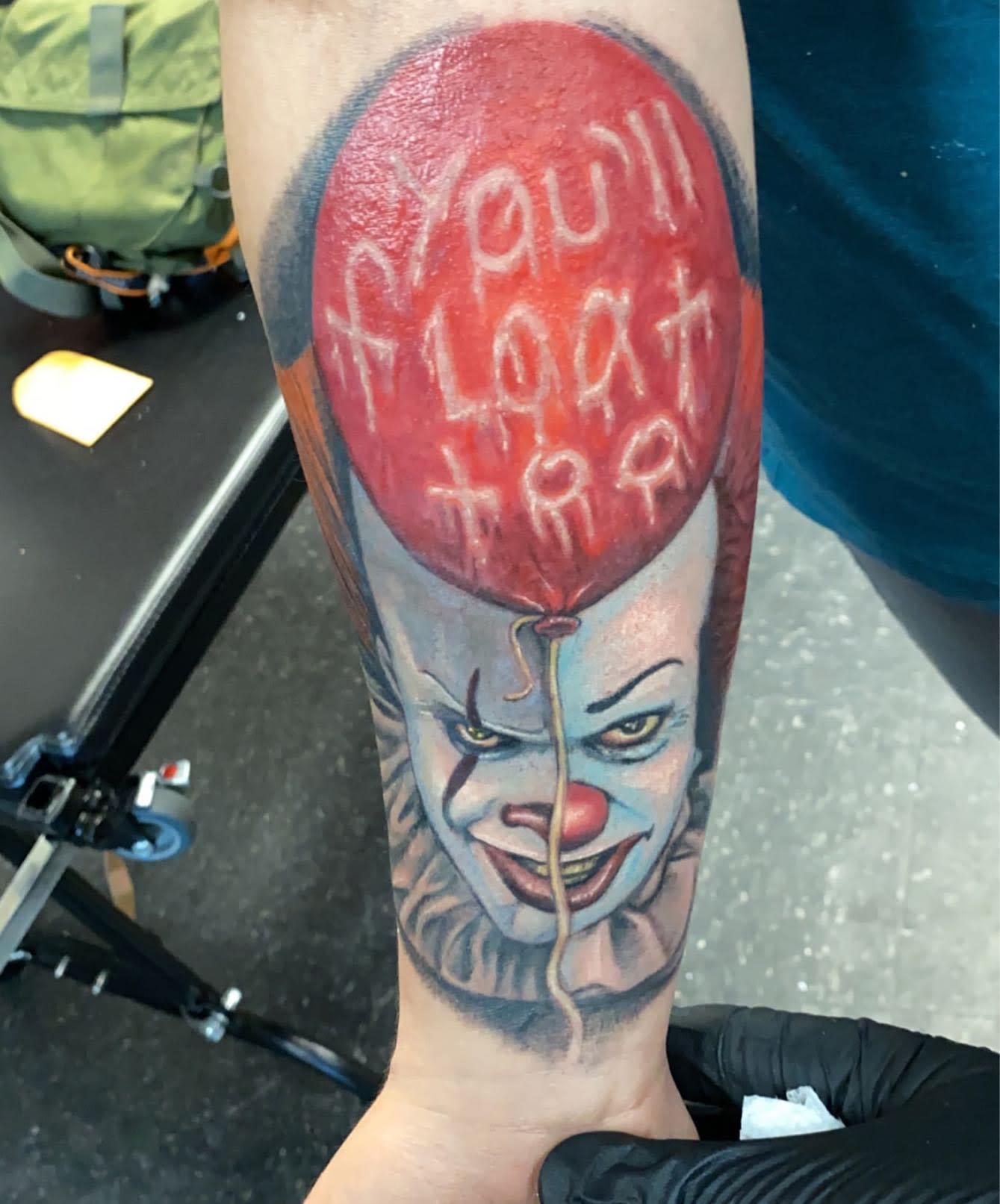 Pennywise tattoo with a red balloon featuring the phrase "You'll Float Too."